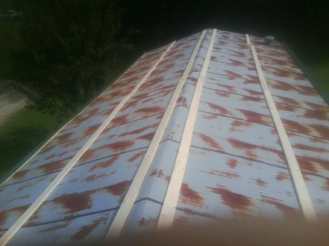 Rusted metal roof panels with new wood purlins before replacement — Storm Damage Roof Repair in Quinton by Roofing Brothers